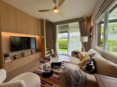 Stylish living room with modern decor and garden view, featuring cozy seating and natural light.