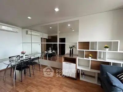 Modern living room with mirrored wall and stylish furniture in a cozy apartment.