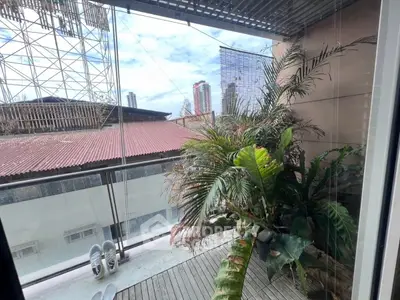 Charming urban balcony with lush greenery and city skyline view.