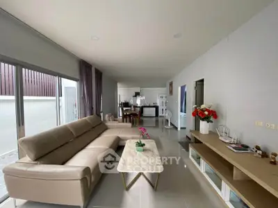 Spacious modern living room with elegant leather sofa and open kitchen layout