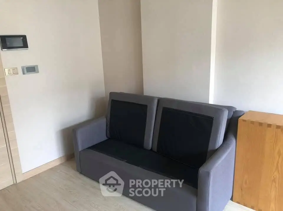 Cozy living room corner with modern gray sofa and wooden accents