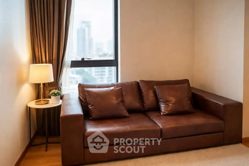 Cozy living room with leather sofa and city view window, perfect for relaxation.