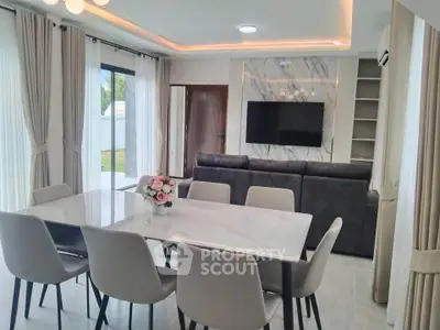 Modern dining area with elegant marble table and stylish chairs, featuring a cozy living room with a wall-mounted TV.