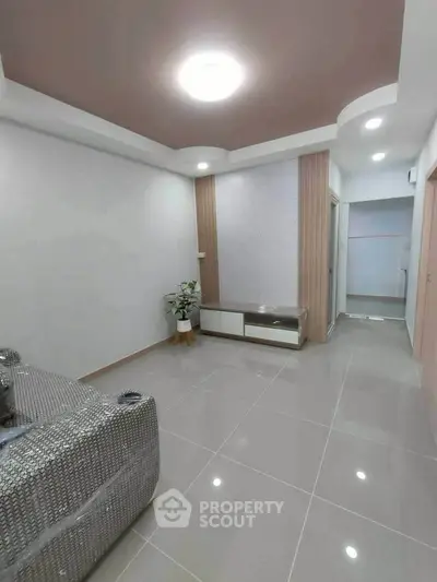 Modern living room with sleek design and glossy tiled flooring, featuring stylish ceiling lights and minimalistic decor.