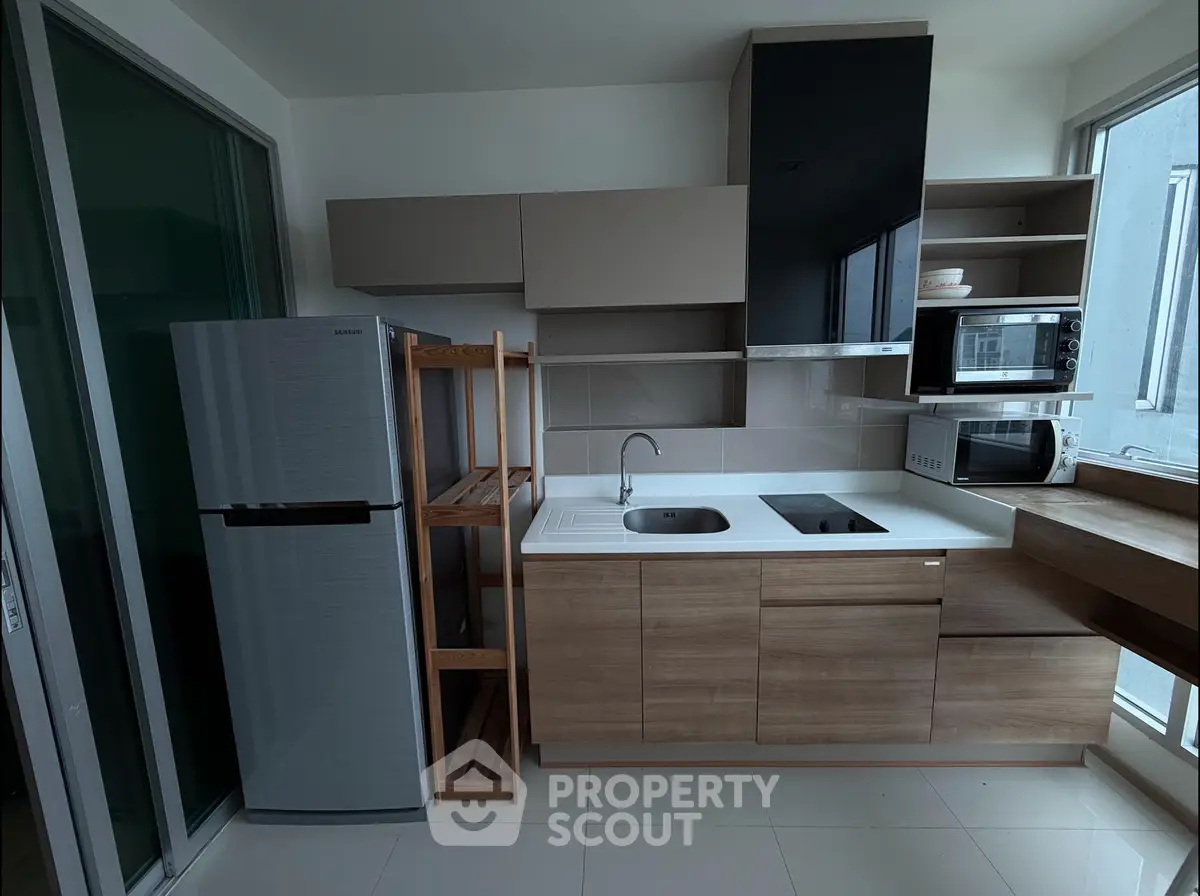 Modern kitchen with sleek cabinets, built-in appliances, and a spacious fridge in a contemporary apartment.