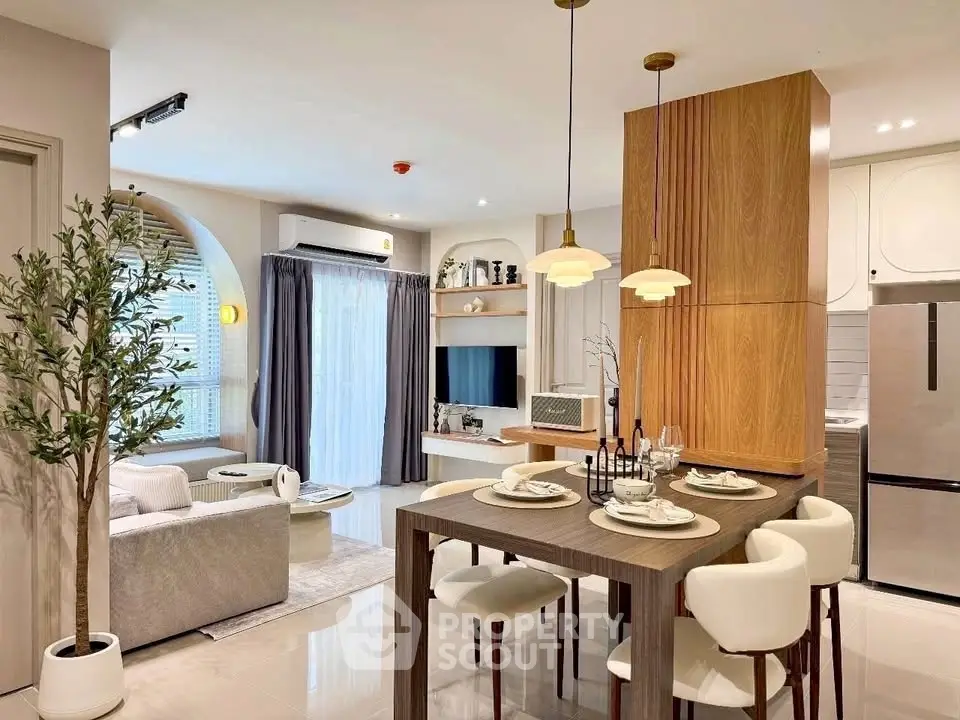 Modern open-plan living room and kitchen with stylish decor and natural light.