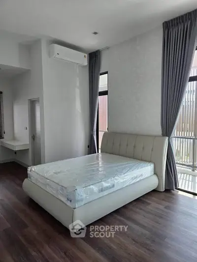 Spacious bedroom with modern design and large windows for natural light.