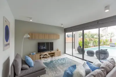 Modern living room with pool view, stylish decor, and natural light