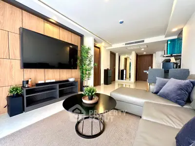 Modern living room with sleek design, large TV, and comfortable seating in a stylish apartment.