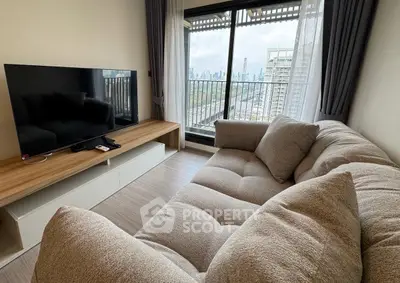 Modern living room with plush sofa and city view balcony in high-rise apartment.