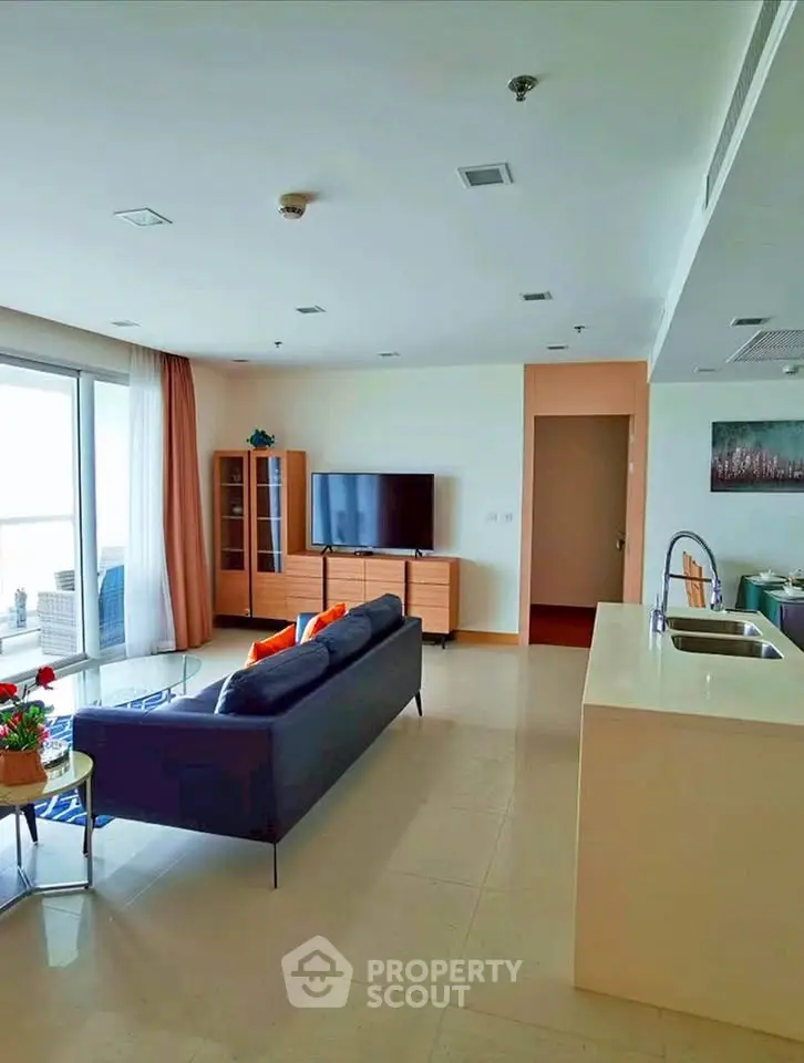 Spacious modern living room with open kitchen and balcony view