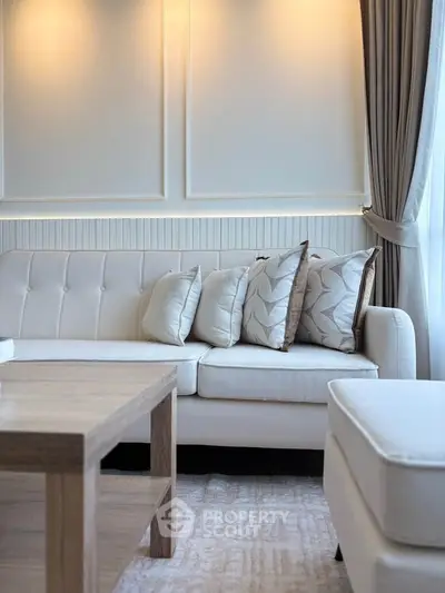 Elegant living room with stylish sofa and wooden coffee table, featuring soft lighting and modern decor.