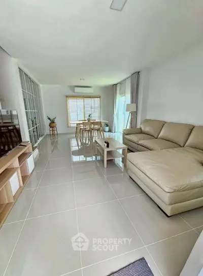 Spacious modern living room with sleek tile flooring and elegant furniture.