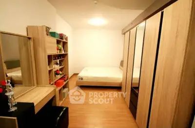 Cozy and well-organized bedroom with ample storage, featuring a large wardrobe, wooden flooring, and a comfortable bed, ideal for restful nights.