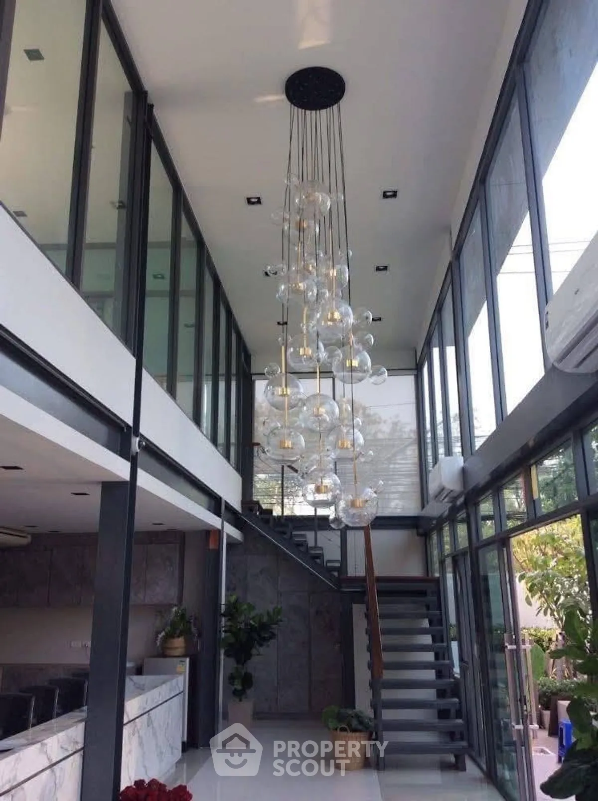 Stunning modern interior with high ceilings and elegant chandelier in a spacious living area.