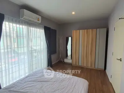 Spacious bedroom with large window and modern wardrobe
