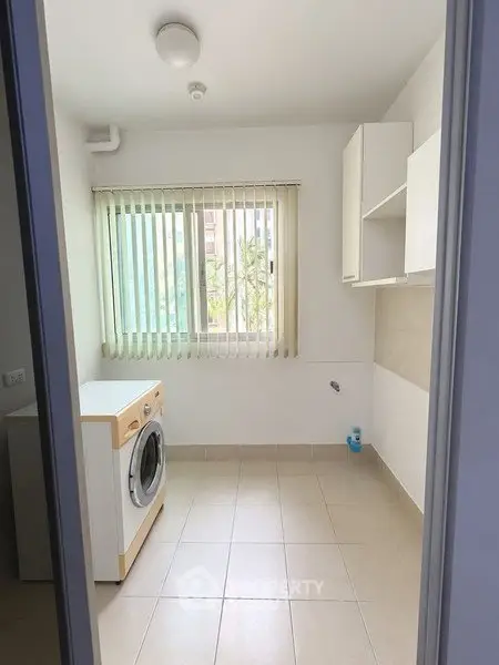 Bright laundry room with washing machine and window view