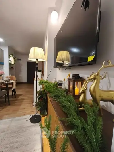 Cozy living room with modern decor, wall-mounted TV, and elegant lighting.
