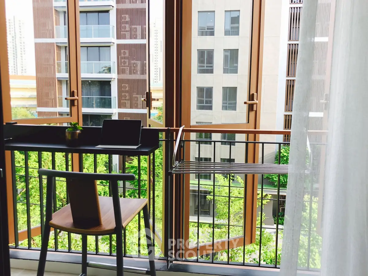 Modern balcony with urban view and stylish furniture, perfect for relaxation and work-from-home setup.