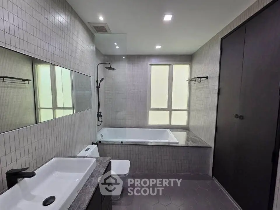 Modern bathroom with sleek design, featuring a bathtub and contemporary fixtures.