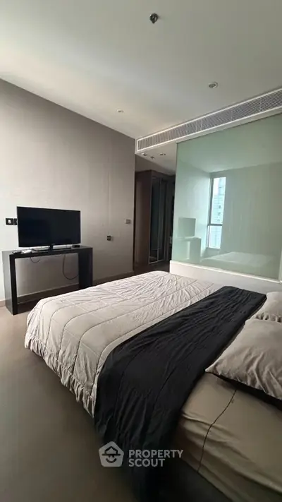 Modern bedroom with sleek design and large window offering natural light.