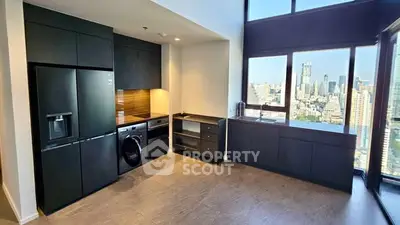 Modern kitchen with sleek black appliances and stunning city view from large windows.