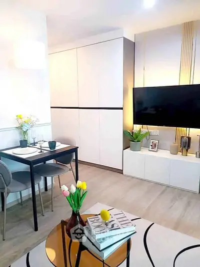 Modern living room with sleek furniture and stylish decor, featuring a mounted TV and cozy dining area.