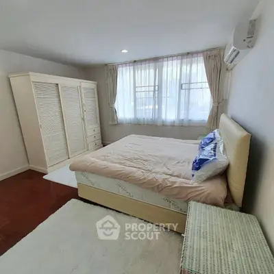 Cozy bedroom with elegant wardrobe and plush bed in bright natural light.