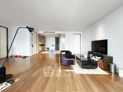 Spacious modern living room with sleek wooden flooring and contemporary furniture.