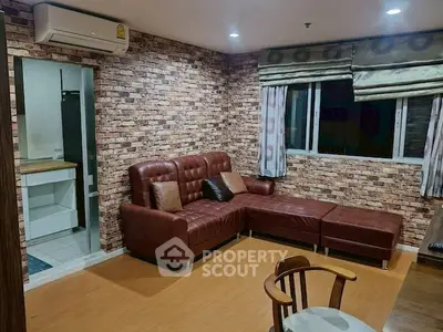 Cozy living room with brick accent wall and leather sectional sofa