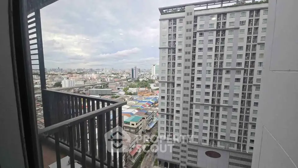 Stunning cityscape view from high-rise balcony overlooking urban skyline and modern apartment building.