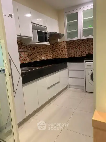 Modern kitchen with sleek white cabinets and mosaic backsplash