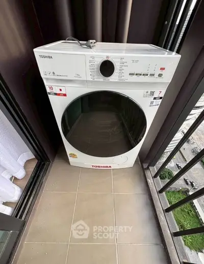 Modern washing machine on a balcony with city view, perfect for urban living convenience.