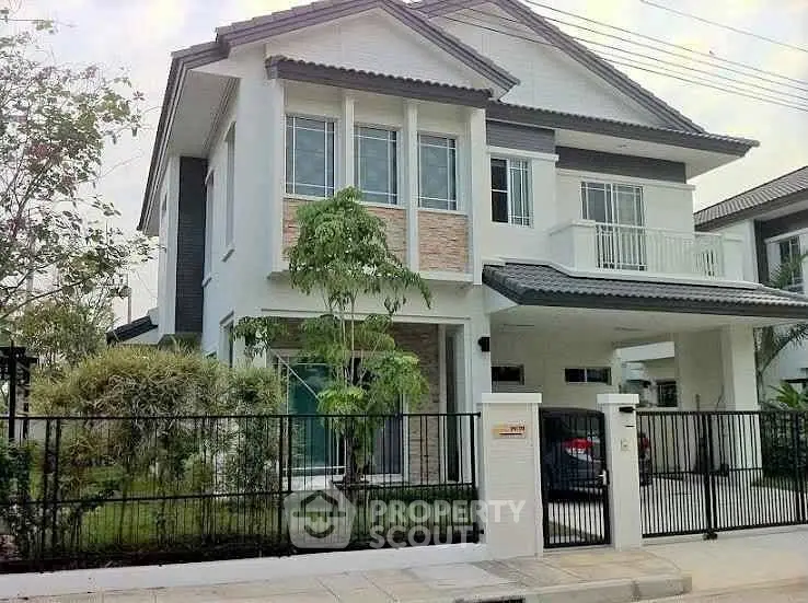 Modern two-story house with landscaped garden and gated entrance