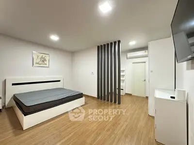 Spacious modern bedroom with minimalist design and wooden flooring