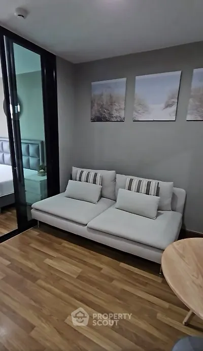 Modern living room with stylish sofa and wooden flooring, perfect for cozy relaxation.
