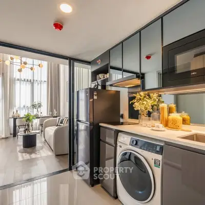 Modern kitchen with sleek appliances and open layout leading to stylish living room.