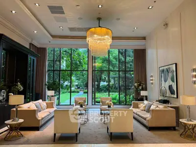 Luxurious living room with elegant chandelier and garden view, perfect for sophisticated gatherings.
