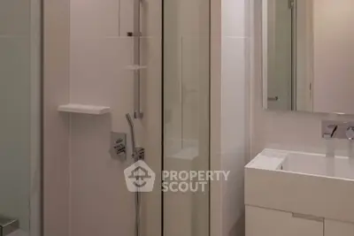 Modern bathroom with sleek shower and vanity in minimalist design.