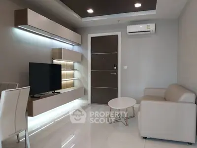 Modern living room with sleek furniture and wall-mounted TV in a stylish apartment.