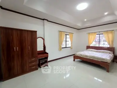 Spacious bedroom with elegant wooden furniture and natural light