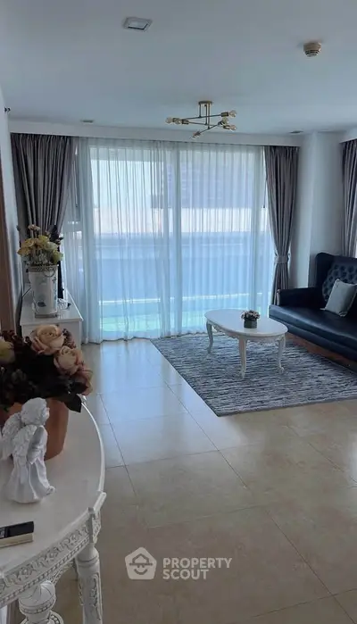 Elegant living room with modern decor and large windows, perfect for relaxation.