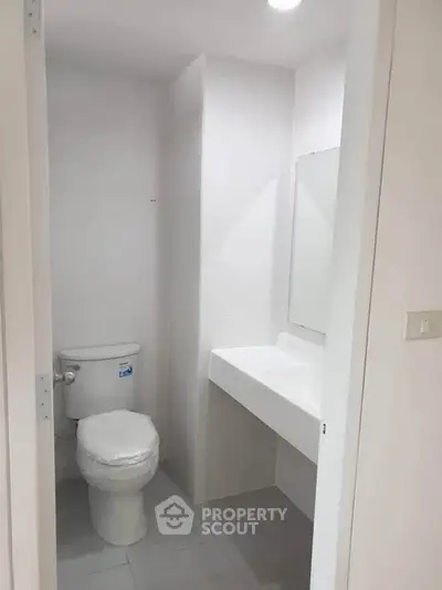 Modern minimalist bathroom with sleek fixtures and neutral tones.