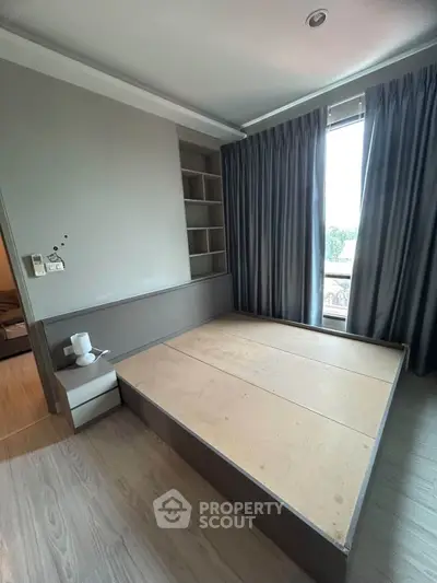 Spacious bedroom with built-in storage and large window for natural light.