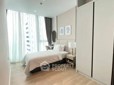 Modern bedroom with large windows, stylish decor, and ample natural light in a high-rise apartment.