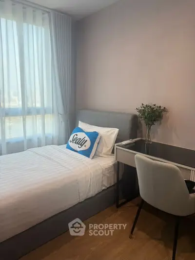 Cozy bedroom with modern decor, featuring a comfortable bed and a stylish desk by the window.