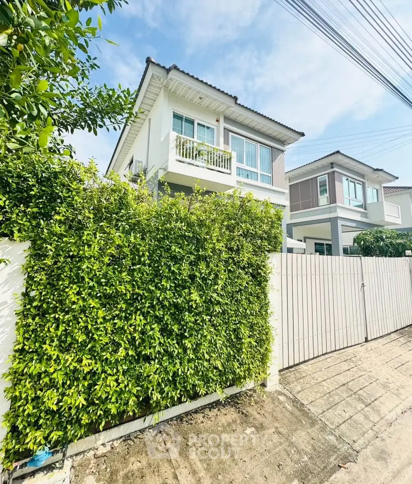 Charming two-story house with lush greenery and modern design in a serene neighborhood.