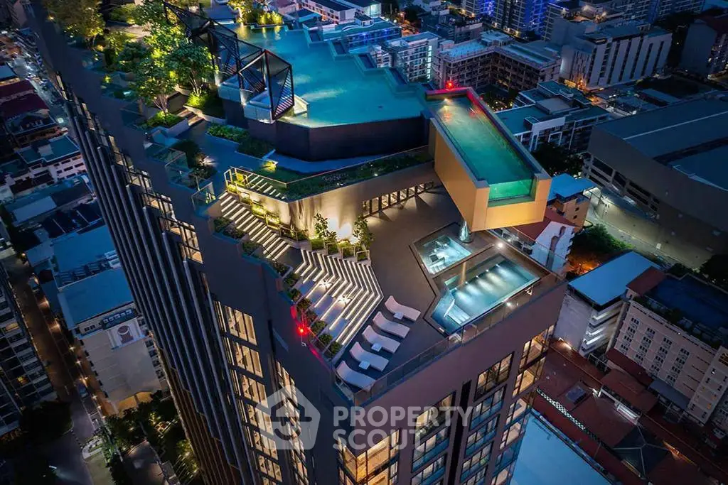 Stunning aerial view of luxury high-rise with rooftop pool and cityscape panorama.