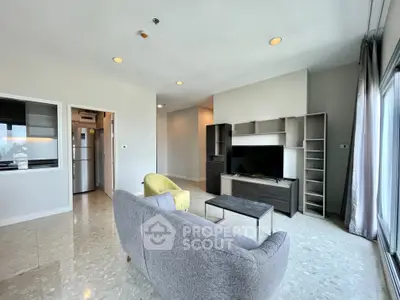 Spacious modern living room with sleek furniture and large windows offering natural light.