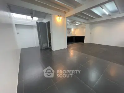 Spacious open-plan living area with modern tiled flooring and ample natural light.